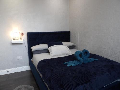 ein Bett mit einem blau ausgestopften Tier, das darauf sitzt in der Unterkunft City Convenience, Calm Comfort-- A Stylish One-Bedroom Retreat Just 3 Stops from the Heart of the City in Edinburgh