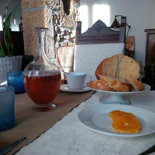 a table with a plate of food and a plate of bread at Maison d'Hôtes Lassaubatju in Hontanx