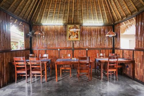 a dining room with wooden tables and chairs at Kampung 168 in Jimbaran