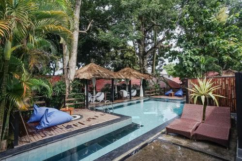 a swimming pool with two chairs and aiki at Kampung 168 in Jimbaran