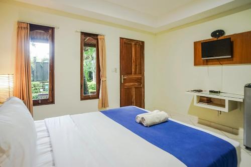 a bedroom with a large bed with a blue blanket at Kampung 168 in Jimbaran