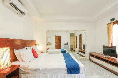a bedroom with a large bed and a mirror at Kampung 168 in Jimbaran
