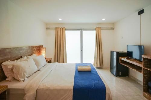 a bedroom with a large bed and a television at Kampung 168 in Jimbaran