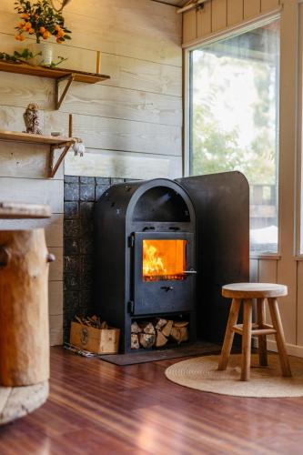 a wood stove in a room with a stool at Le Chalet de l'Ours, jacuzzi and private sauna in Insemont