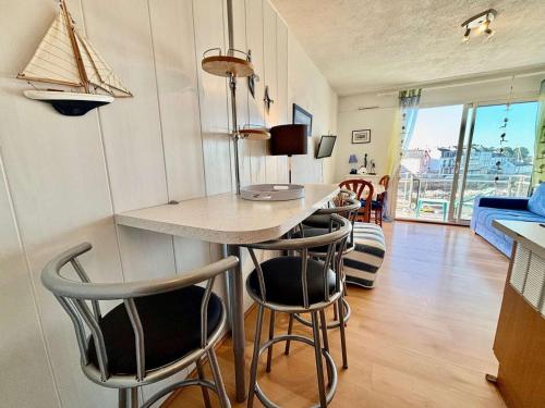 une cuisine avec une table et des chaises dans une pièce dans l'établissement Studio cosy à Quiberon avec balcon, parking et animaux acceptés - FR-1-478-45, à Quiberon