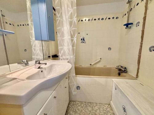 une salle de bain avec un lavabo et une baignoire dans l'établissement Studio cosy à Quiberon avec balcon, parking et animaux acceptés - FR-1-478-45, à Quiberon