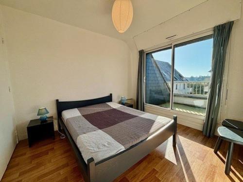 une chambre avec un lit et une grande fenêtre dans l'établissement Quiberon - 2 Pièces + Mezzanine avec 2 Balcons, Parking, Près de la Mer - FR-1-478-125, à Quiberon