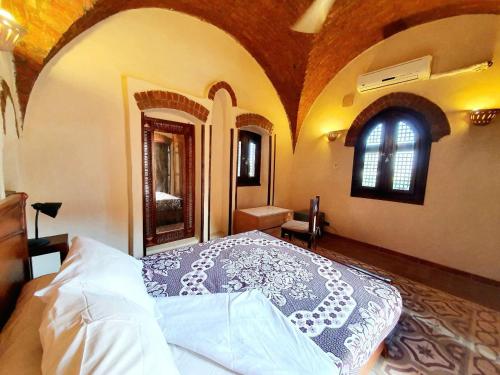 a bedroom with a bed in a room with a window at Villa Rosamund in Luxor