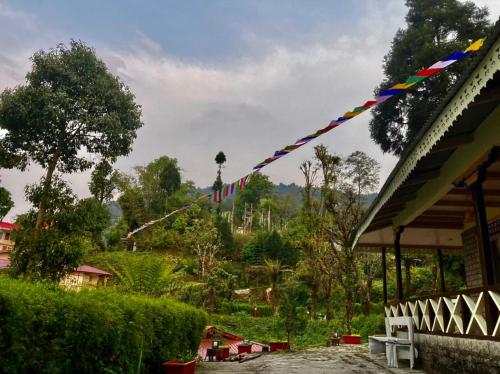 a kite with a long tail flying in the sky at MayaTels - Maya Eco Huts, Pelling in Pelling