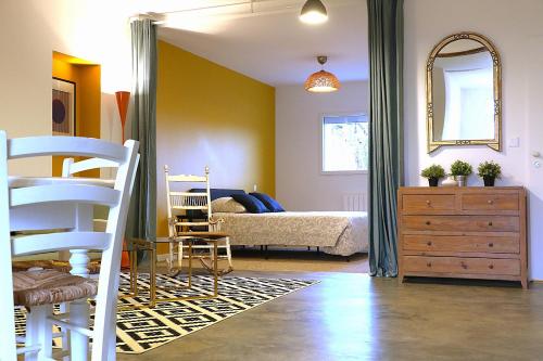 a bedroom with a bed and a dresser and a mirror at Plain pied cosy à 20 minutes de bordeaux - Le Clos Montichamp in Camblanes-et-Meynac