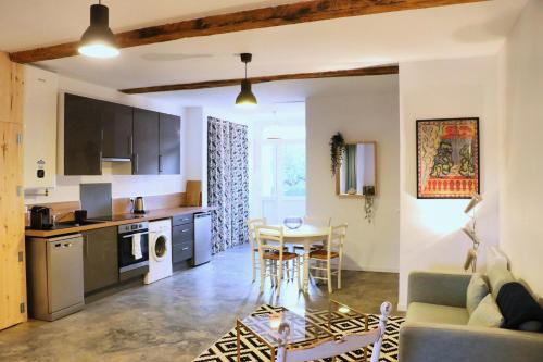 une cuisine et un salon avec une table et des chaises dans l'établissement Plain pied cosy à 20 minutes de bordeaux - Le Clos Montichamp, à Camblanes-et-Meynac