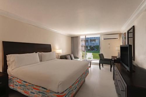 a hotel room with a bed and a television at Catalonia Montego Bay - All Inclusive in Montego Bay