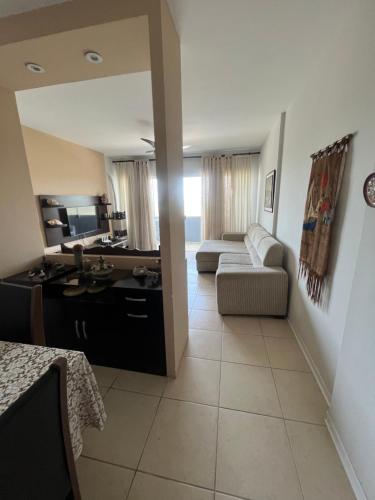 a living room with a couch and a table in a room at Pé na areia incrível in Piçarras