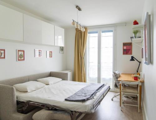 une chambre avec un lit, un bureau et une fenêtre dans l'établissement Cosy studio Métro 14, 13, à Paris