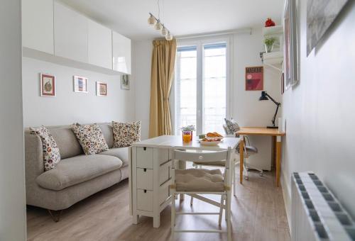 un salon avec un canapé et une table dans l'établissement Cosy studio Métro 14, 13, à Paris