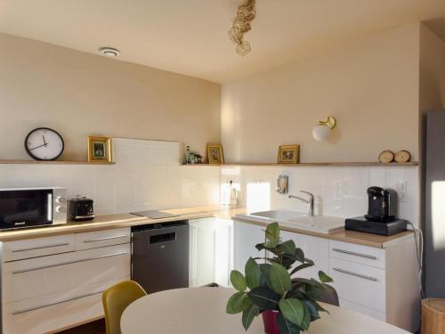 une cuisine avec des placards blancs et une horloge murale dans l'établissement Duplex lumineux 2 chambres centre zone piétonne, à Valence