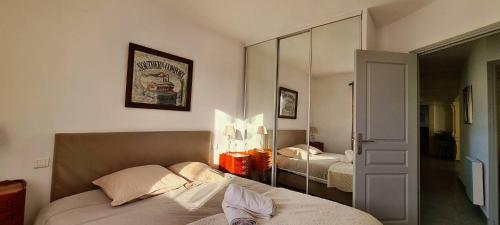 une chambre avec un lit et un miroir dans l'établissement Villa Syrah, à Châteauneuf-du-Pape