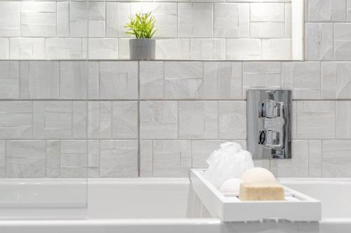 a white bathroom with a tub and a sink at Bond House by Celador Apartments in Reading