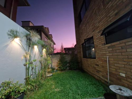 a backyard of a house with a grass yard at Departamento excelente ubicación con parqueo in Cuenca