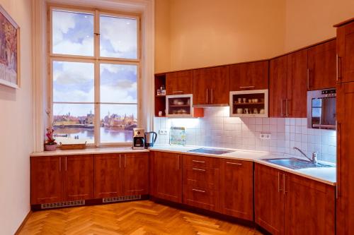 uma cozinha com armários de madeira e uma grande janela em Apartment Vodičkova 11 em Praga