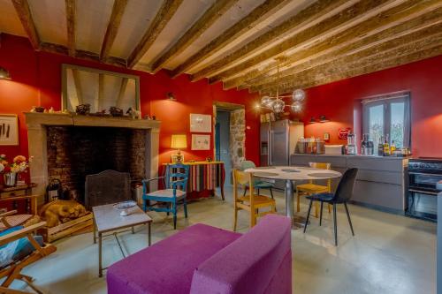 un salon avec un canapé violet et une cheminée dans l'établissement Le Logis de la Veillere - Grand Jardin de 1 000 m², à Villaines-la-Gonais