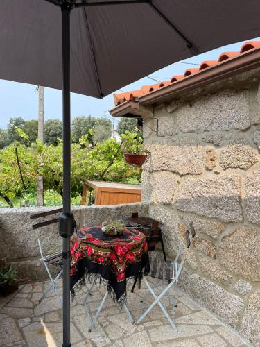 a table with an umbrella on a patio at CASA DA QUELHA in Soajo