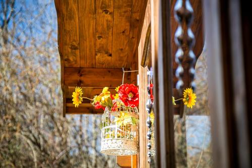 a vase filled with flowers hanging from a window at Il Borghetto in Lanzo dʼIntelvi