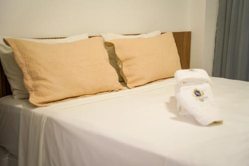 a white bed with pillows and a towel on it at EL SHADDAI HOTEL in João Pessoa