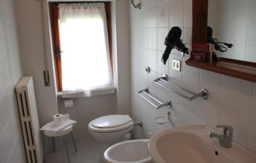 a white bathroom with a toilet and a sink at Hotel Adriana in Abbadia San Salvatore
