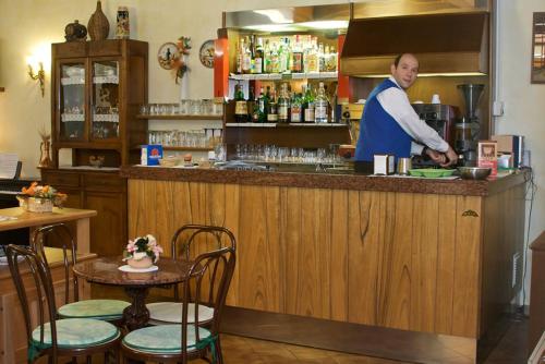 a man in a kitchen preparing food at a bar at Hotel Adriana in Abbadia San Salvatore
