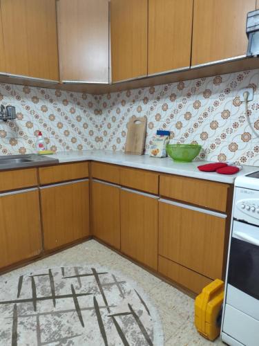 a kitchen with wooden cabinets and a white stove at Σπίτι τετράκλινο με θεα Φλώρινα in Florina
