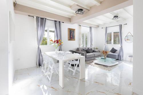 un salon blanc avec une table et un canapé dans l'établissement Stunning Seaview White Villa in Beuasoleil with Pool and Garden, à Beausoleil