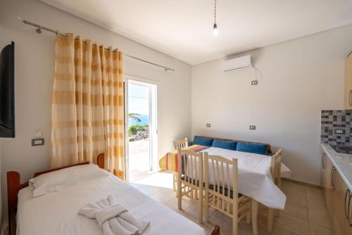 a bedroom with a bed and a table and a window at Vila Celi in Sarandë
