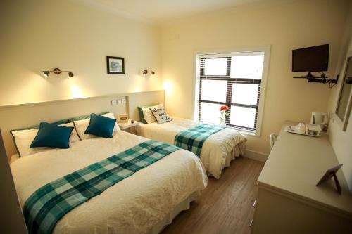 a hotel room with two beds and a window at Slidala B&B in Roscrea