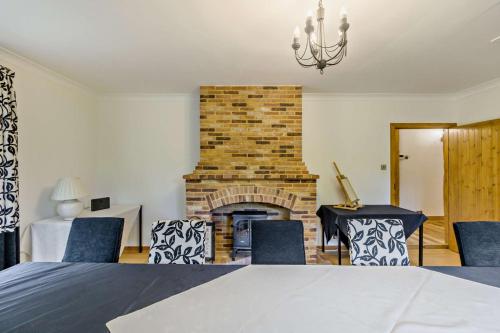 a bedroom with a brick fireplace and blue chairs at Finest Retreats - The House at No 47 in West Wickham