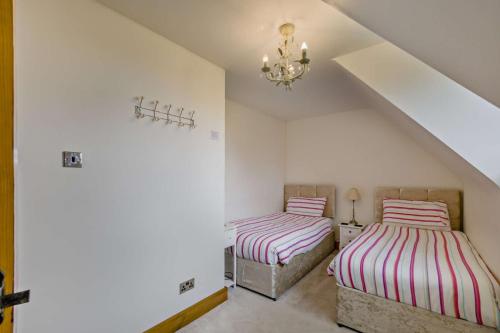 two beds in a room with white walls at Finest Retreats - The House at No 47 in West Wickham