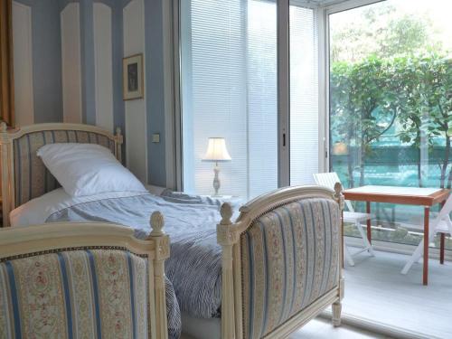 une chambre avec un lit, une table et une fenêtre dans l'établissement Appartement jardin, à Cannes
