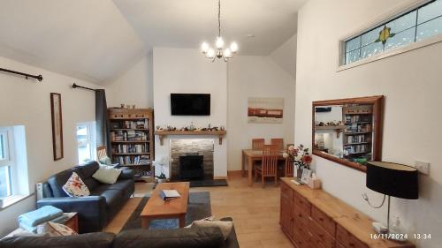 un salon avec un canapé et une cheminée dans l'établissement Bovinda Cottage - By the Beach, Bettystown, à Bettystown