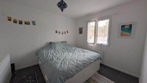 une petite chambre avec un lit et une fenêtre dans l'établissement Appartement avec jardin proche de l'océan, à Saint-Julien-en-Born