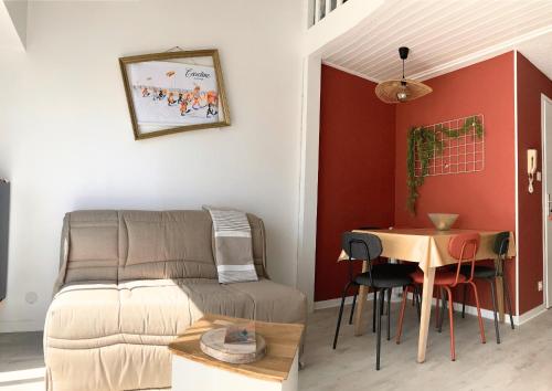 un salon avec un canapé et une table dans l'établissement Le doux refuge aperçu mer, à Les Sables-dʼOlonne