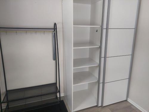 a closet with white shelves and a glass door at Halfway in Kabelvåg