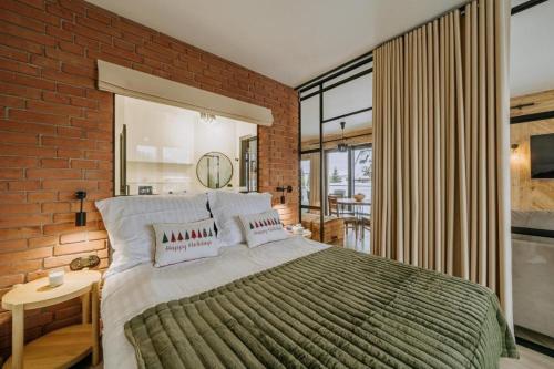 a bedroom with a large bed and a brick wall at Tatra Panorama Residence - Ski, Hike & Relax Retreat in Zakopane