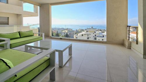 a living room with a couch and a glass table at Tabarja Hills apartment in ‘Ayn aş Şughayrah