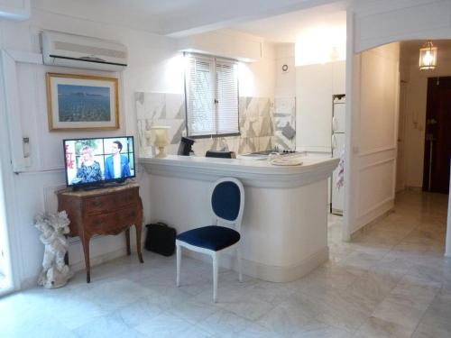 Cette chambre dispose d'un comptoir avec une chaise bleue et d'un bureau. dans l'établissement Appartement jardin, à Cannes