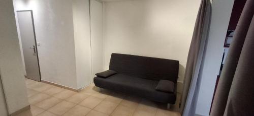 une chaise noire assise dans une pièce avec porte dans l'établissement Studio Village Camarguais, à Arles