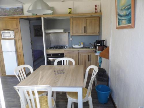 a small kitchen with a wooden table and chairs at le petit marais n1 in Nouan-le-Fuzelier