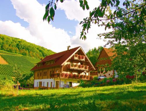 a large house with flowers on the front of it at Weingut und Ferienhof Josef Huber in Oberkirch