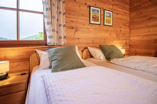 two beds in a room with wooden walls at Weingut und Ferienhof Josef Huber in Oberkirch