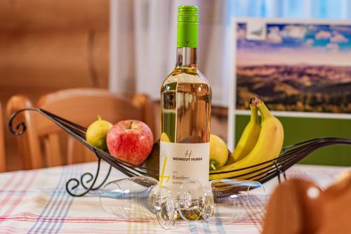 a bottle of wine and fruit on a table at Weingut und Ferienhof Josef Huber in Oberkirch