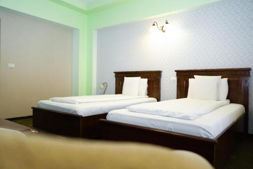 two beds in a small room with at Popasul Caprioarei in Pădureni